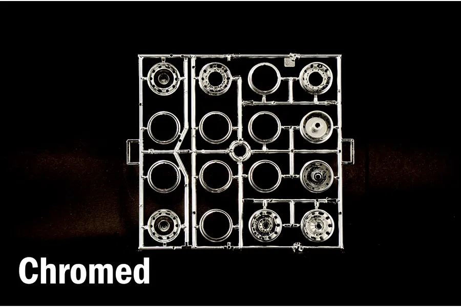 Chrome plated plastic model kit parts sprue containing wheels and rims on a black background.