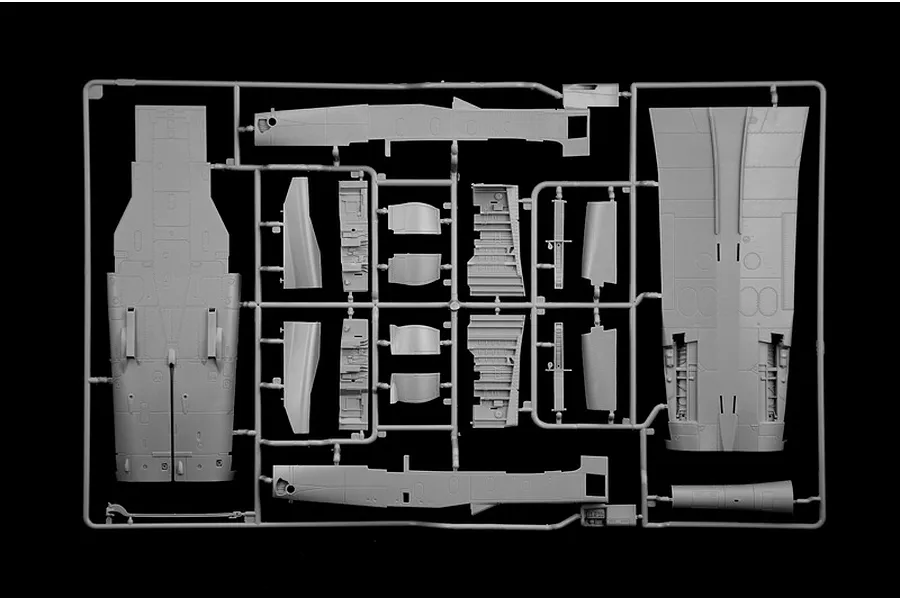A grey plastic model kit sprue containing aircraft parts like fuselage and wing sections against a black background.