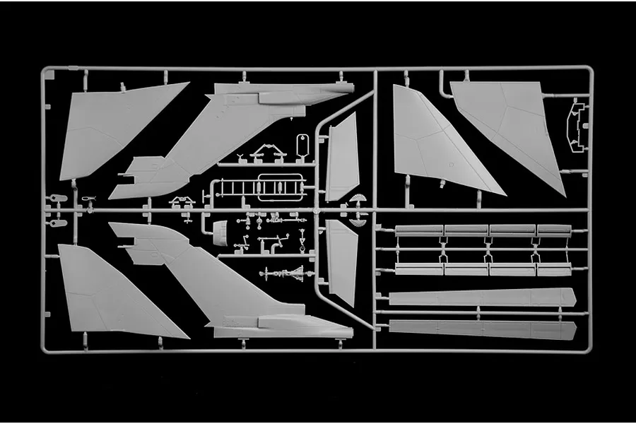 A grey plastic model kit sprue containing aircraft parts such as wings, tail sections, and smaller components on a black background.