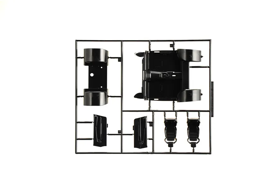 Black plastic model kit sprue containing interior car parts such as seats, floor pan, and door panels.