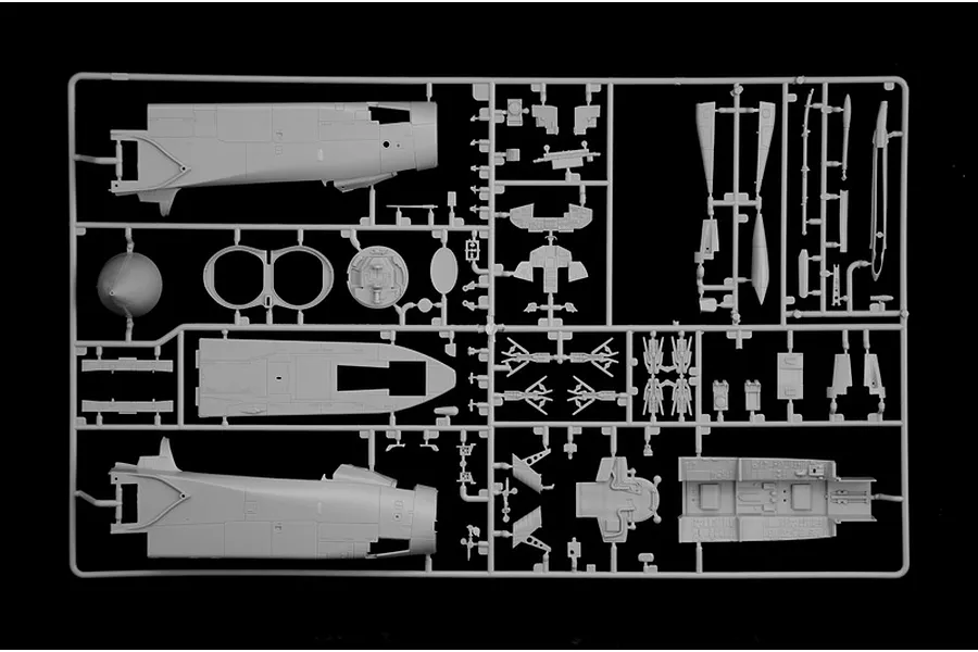 Grey plastic model kit sprue containing various aircraft parts and fuselage sections on a plain black background.