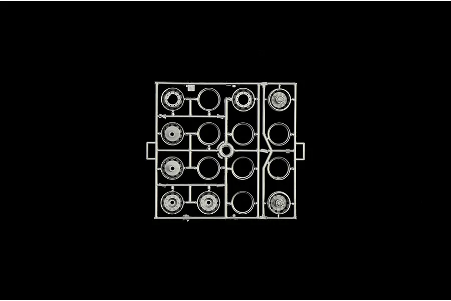 A grey plastic model sprue featuring various scale truck wheel rims and hub components on a solid black background.