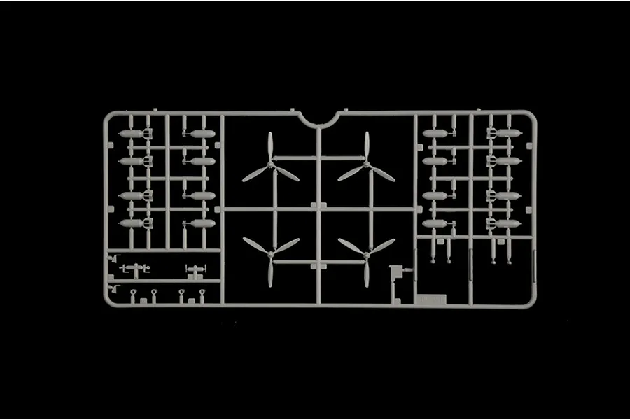 Grey plastic model sprue featuring four propeller assemblies and numerous bomb parts on a black background.
