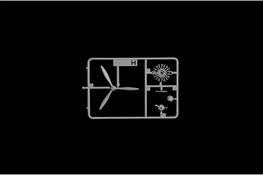Grey plastic model kit sprue containing a three-bladed propeller, radial engine, and small components against a plain black background.