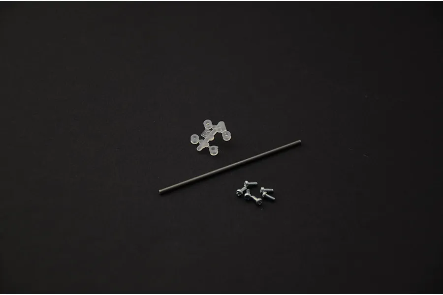 Small plastic parts sprue, metal axle rod, and four screws on a dark background for Italeri model kit.