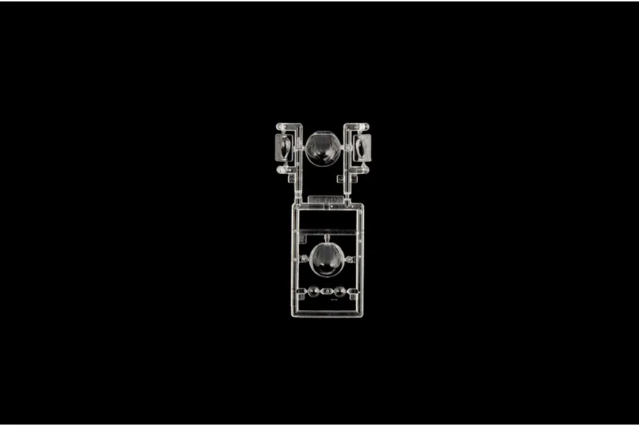 Clear plastic model kit sprue containing transparent windows and turrets on a plain black background.