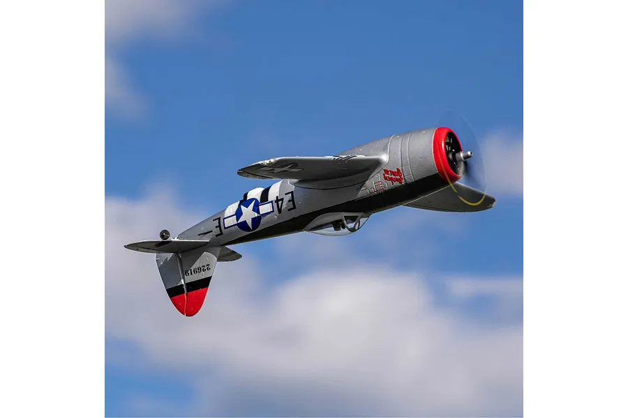 An E-Flite micro P-47 Thunderbolt RC warbird plane flying in a blue sky with light clouds.