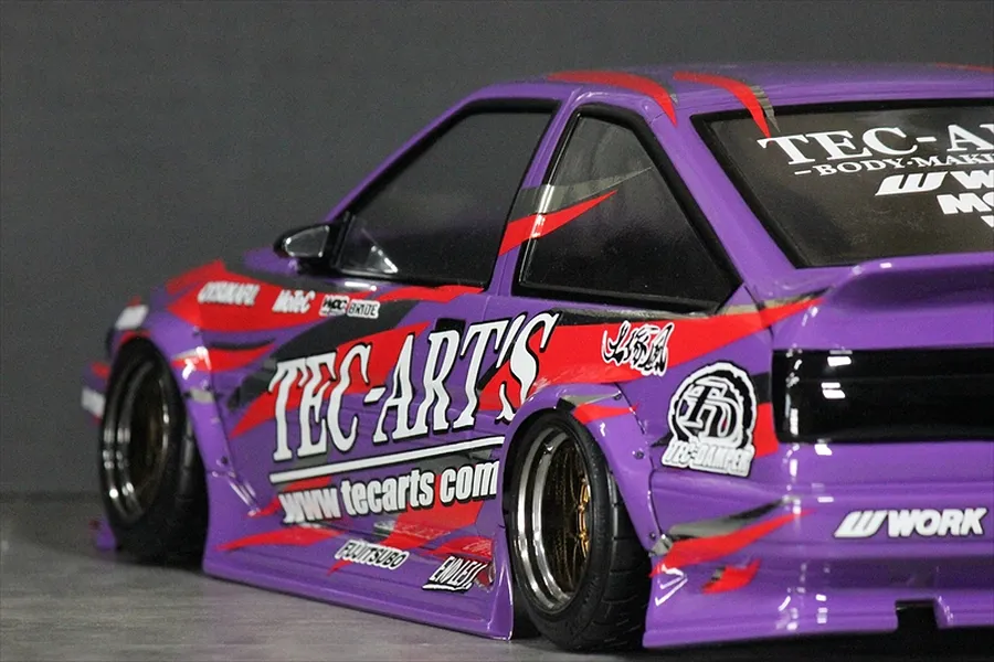 Close-up of a purple RC drift car body installed with TEC-ART'S decals and sponsor logos.