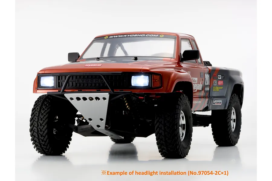 Front three-quarter view of the Kyosho Outlaw Renegade RC truck featuring illuminated headlights on a white background.