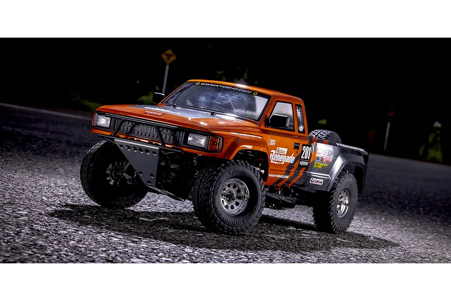 Kyosho Outlaw Renegade 2RSA RC Short Course Truck parked on an outdoor paved surface at twilight.