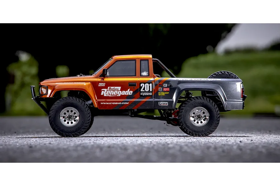 Kyosho Outlaw Renegade 1/10 scale electric RC short course truck photographed from the side on an outdoor surface