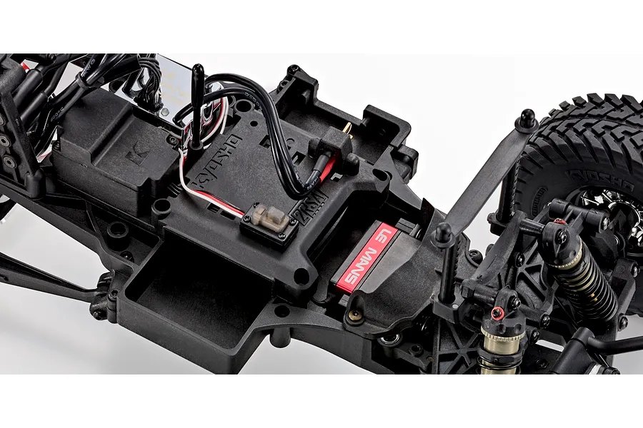Close-up of the chassis interior of the Kyosho Outlaw Renegade 2RSA RC short course truck showing electronics and motor.