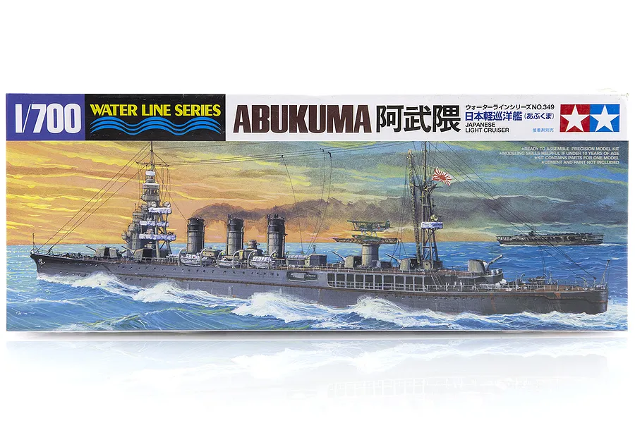 Tamiya 1/700 scale Japanese Abukuma Light Cruiser plastic model kit box art showing the ship at sea at sunset.