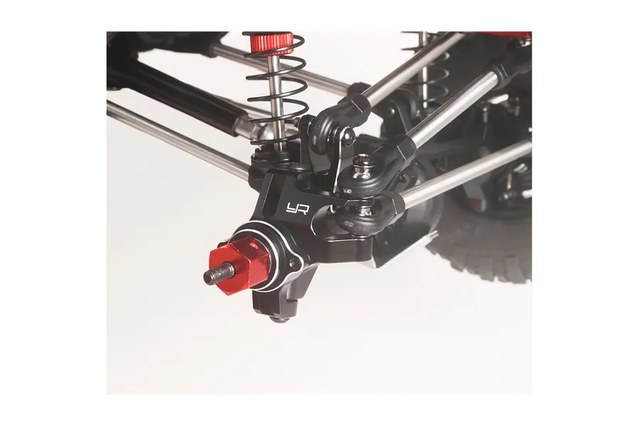 Close-up of Yeah Racing black aluminium front steering hub carrier installed on an RC crawler suspension against a plain background.