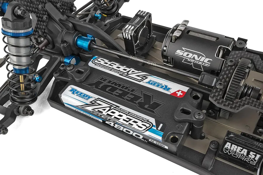 Close-up studio view of the chassis, electronics, motor, and Reedy Zappers batteries installed in a Team Associated RC buggy.