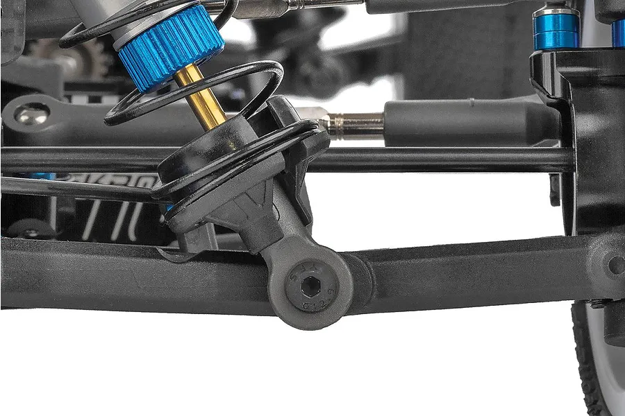 Close-up of the front suspension and blue aluminum shock absorber on the Team Associated RC10B84.1D RC buggy.