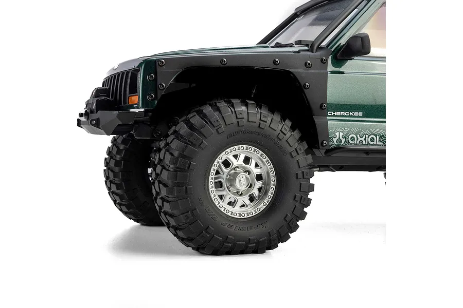 Close-up of front wheel and green body of Axial SCX10 III Jeep Cherokee XJ RC crawler.