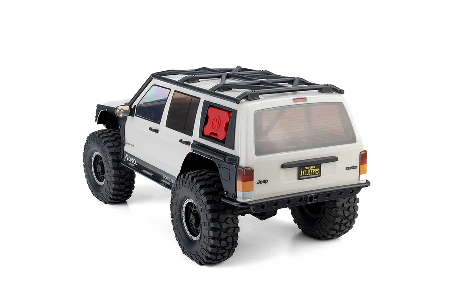 Rear three-quarter view of the Axial SCX10 III Jeep Cherokee XJ RC rock crawler in white with a roof rack and red fuel can.