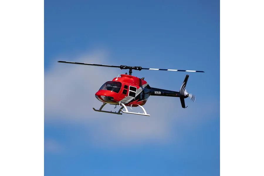 Blade Jet Ranger 235CP RC helicopter in flight against a clear blue sky with light clouds.