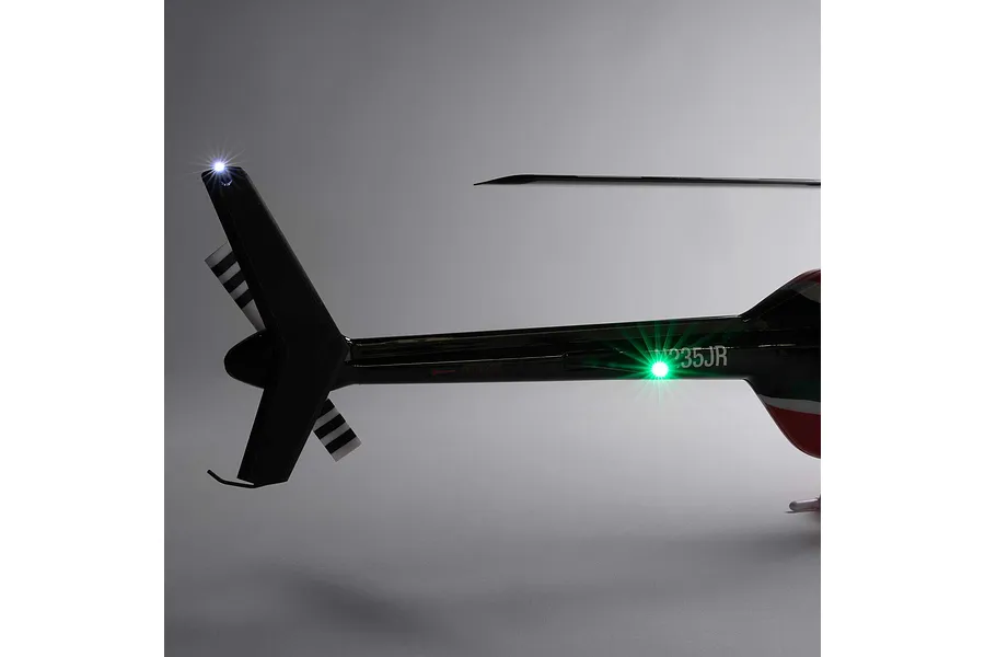 Close-up studio view of the tail section of the Blade Jet Ranger 235CP RC helicopter, highlighting the illuminated tail light and markings.