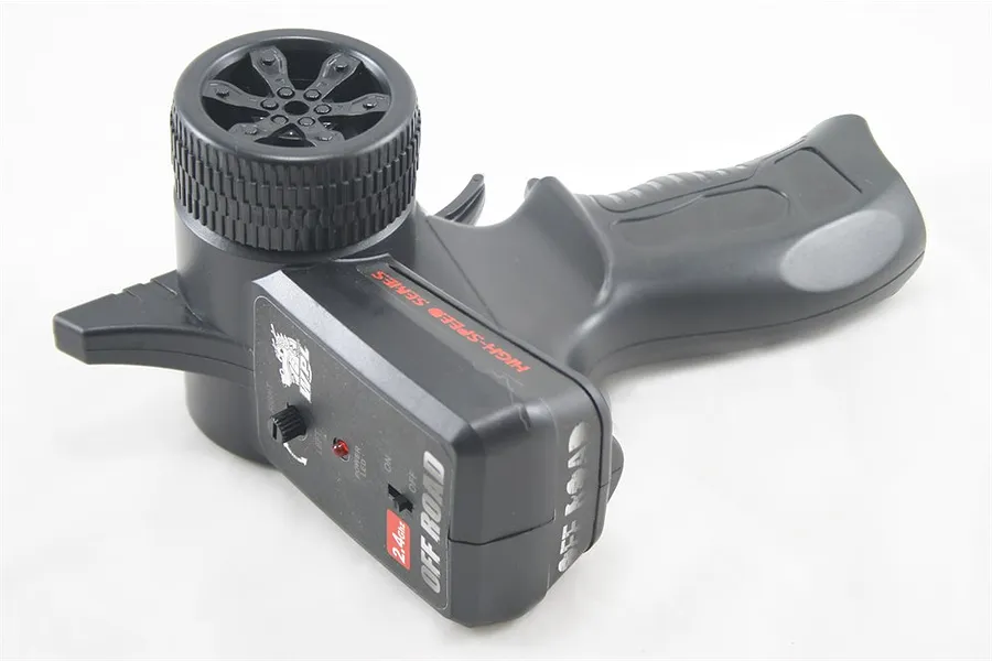 WPL 2.4Ghz pistol-grip radio transmitter featuring a black plastic housing, steering wheel, trigger, and control panel with an on/off switch.