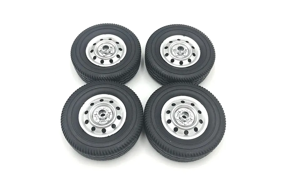 Four WPL 1/10 scale rubber tyres mounted on silver rims viewed from above on a white background.