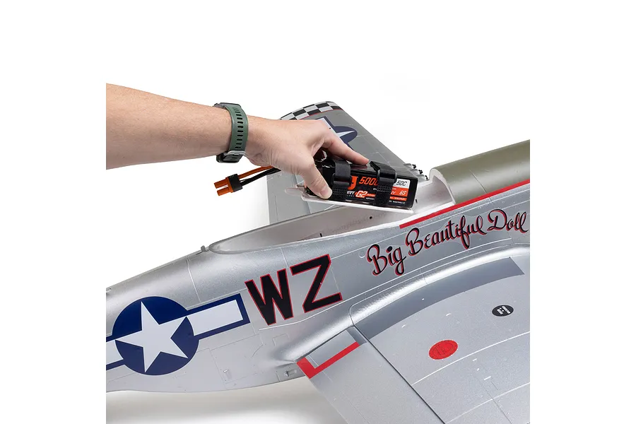 A person installing a LiPo battery into the fuselage of an E-Flite P-51D Mustang Big Beautiful Doll RC airplane.