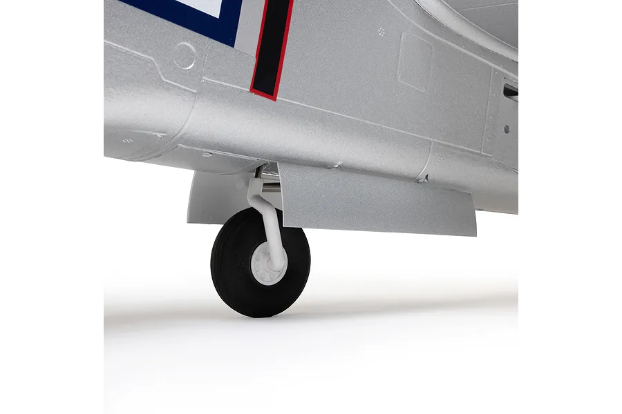 Close-up of retractable landing gear on the silver fuselage of an E-Flite P-51D Mustang RC airplane.