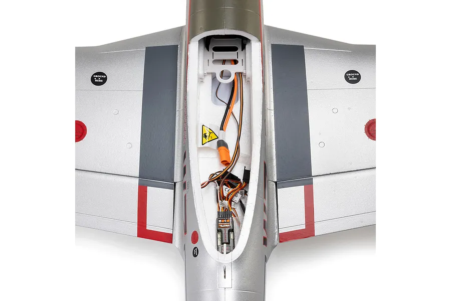 Top-down view of the electronics bay and receiver inside the silver foam fuselage of an E-Flite P-51D Mustang RC airplane.
