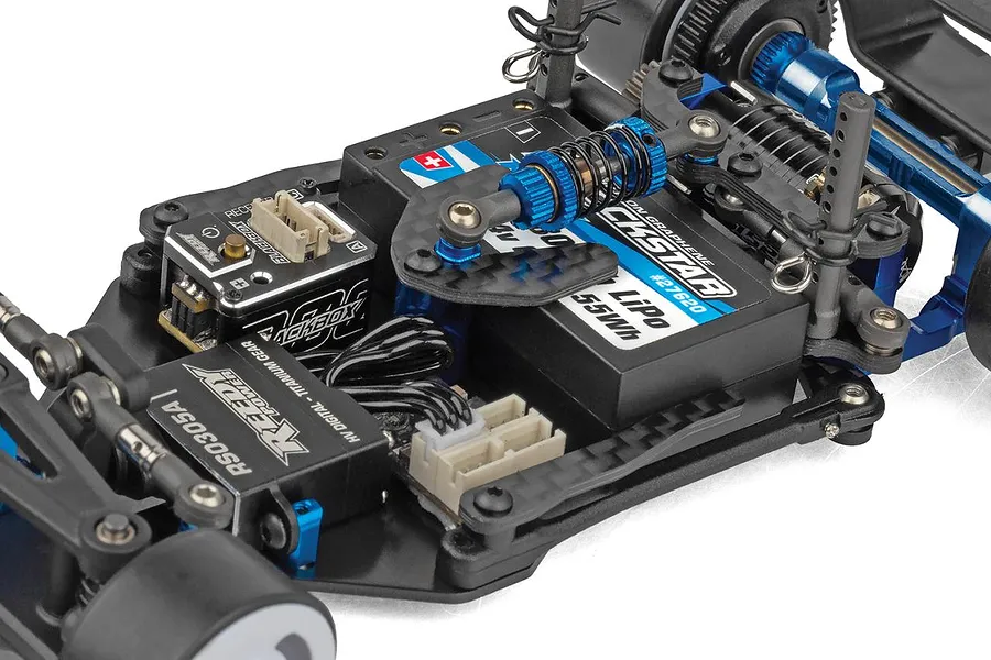 Close-up view of the internal electronics chassis layout of the Team Associated RC28F RC car showing battery, servo, and suspension components.