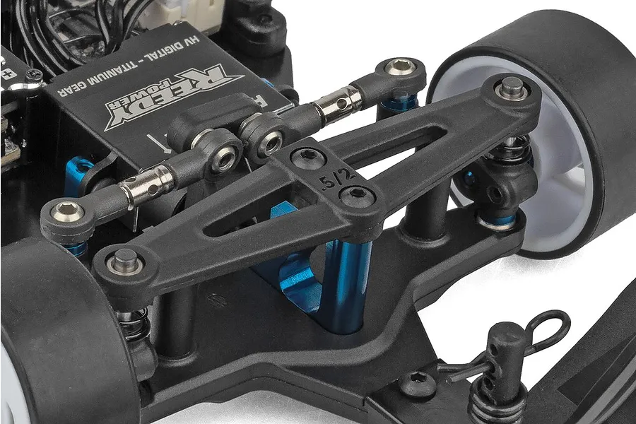 Close-up view of the front suspension, steering linkage, and Reedy Power servo on an RC car.
