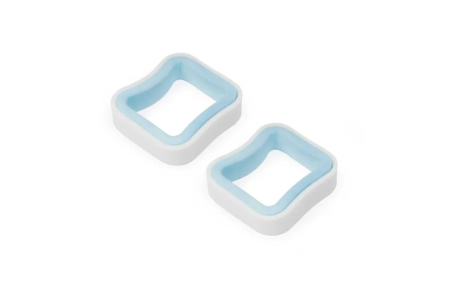 Two square foam air filter elements with white and light blue layers against a clean white background.