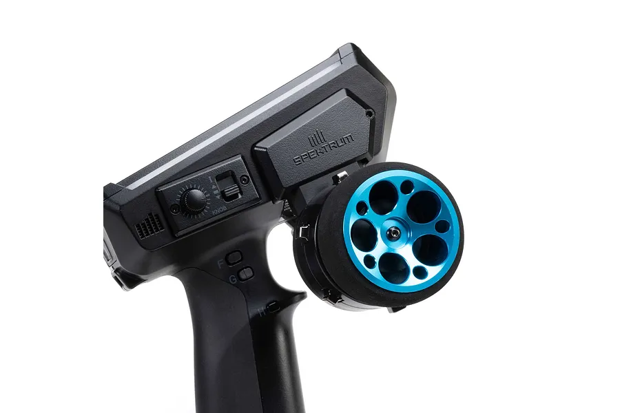 Spektrum wide blue aluminium wheel installed on a black RC transmitter against a white background.
