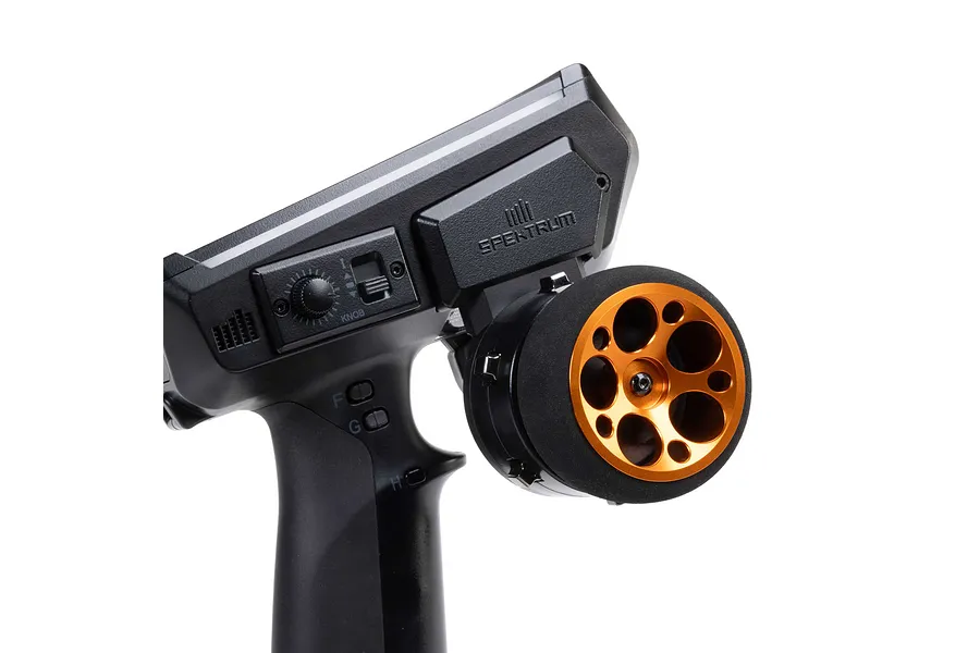 Close-up of a Spektrum RC transmitter installed with an orange aluminium wide circle wheel accessory against a white background.