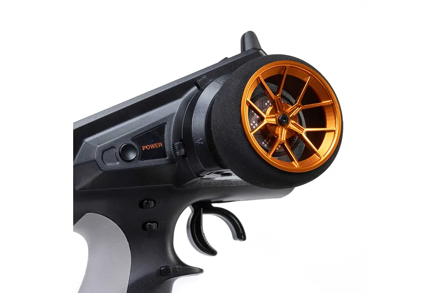 Close-up of an orange aluminium wide spoke transmitter wheel installed on a black RC transmitter against a white background.