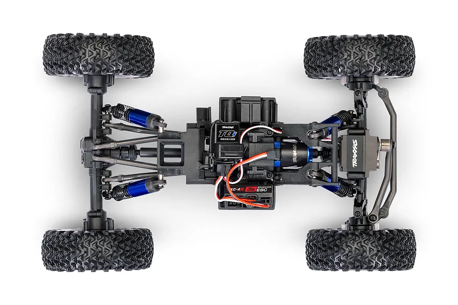Top-down studio view of the chassis, suspension, receiver, and ESC of a Traxxas TXC-4M RC crawler.
