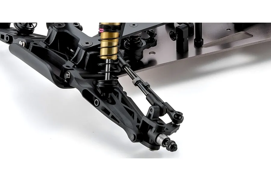 Close-up studio view of the front suspension, metal shock absorber, and chassis of the Kyosho Ultima Pro RC buggy kit.