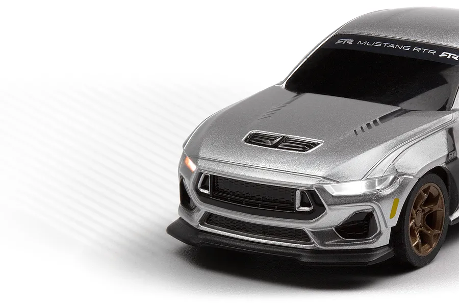 Close-up studio shot of the front quarter of the silver HPI Nano-TTR Ford Mustang Spec 5 RC car with illuminated headlights.