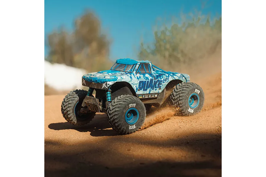 ARRMA Quake 4S blue monster truck kicking up dirt dust on an outdoor dirt track