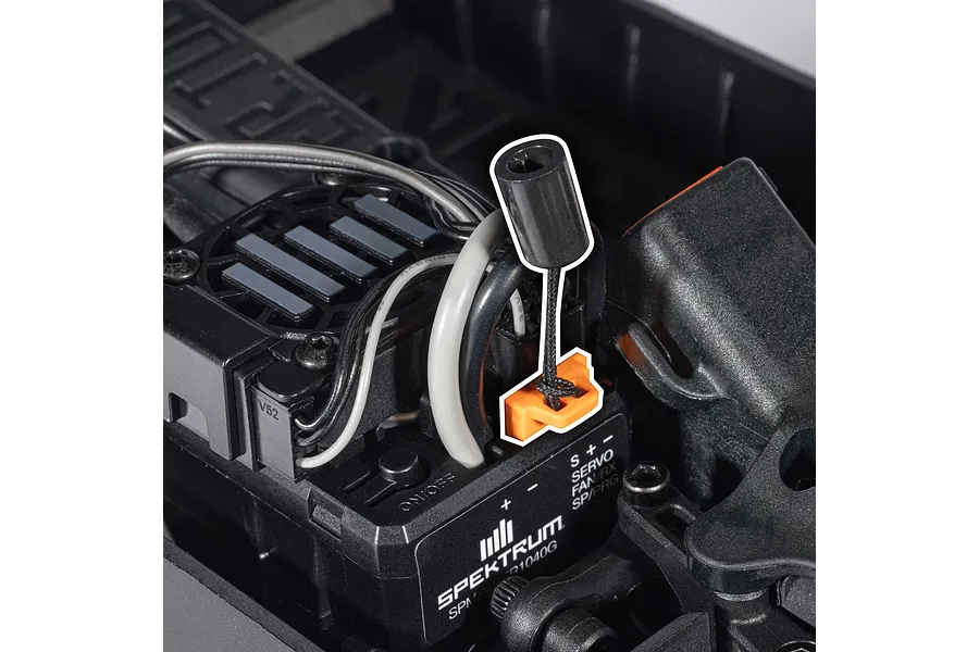 Close-up of Spektrum electronics and wiring inside an RC car chassis with an antenna tube highlighted.