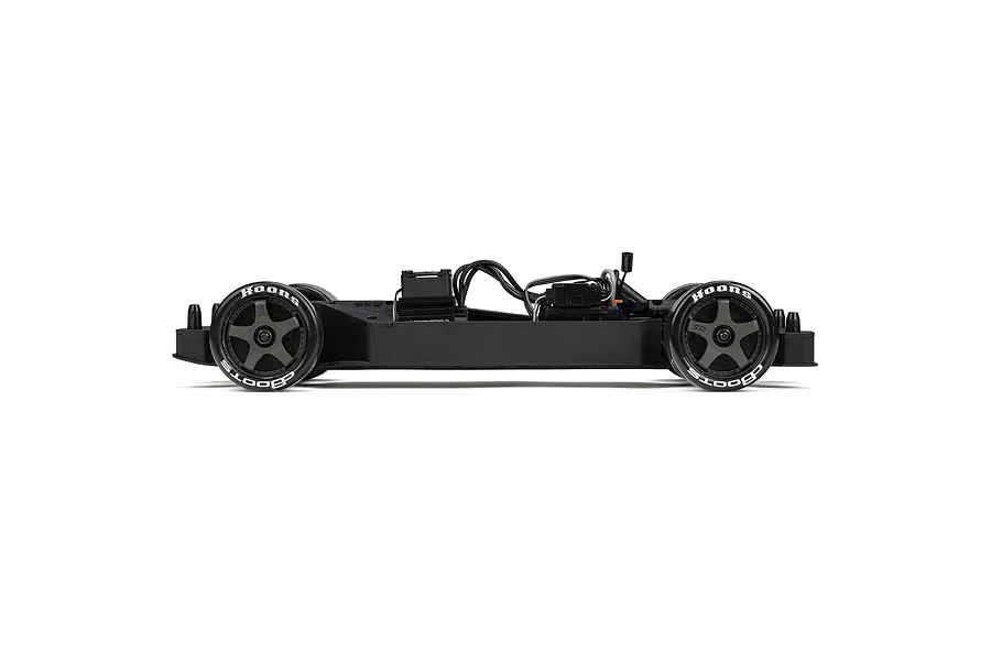 Side view of the black chassis and electronics of the ARRMA Infraction Grom 3S RC car against a plain white background.