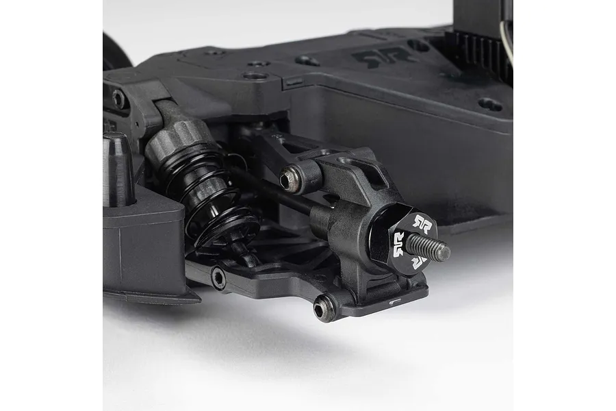Close-up of the front suspension, shock absorber, and wheel hub assembly on a black RC car chassis.