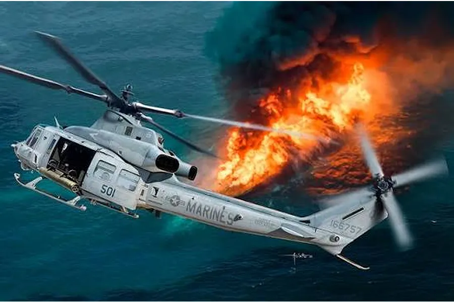 Artwork of a US Marines UH-1Y Venom helicopter flying over water near a large fire and smoke cloud.