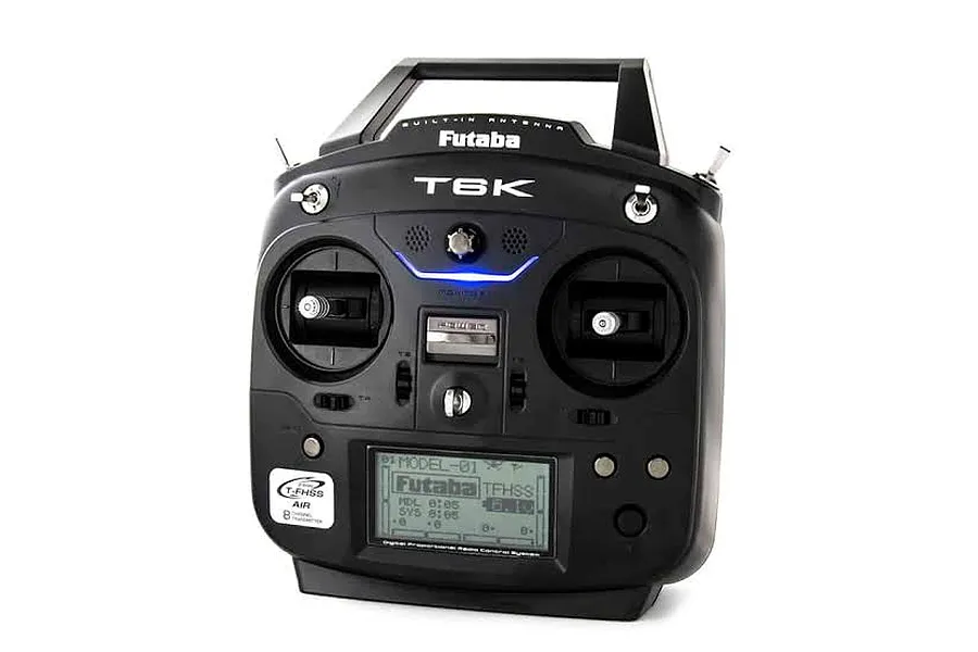 Front studio view of the black Futaba T6K radio transmitter featuring dual gimbals, switches, and a digital LCD screen.