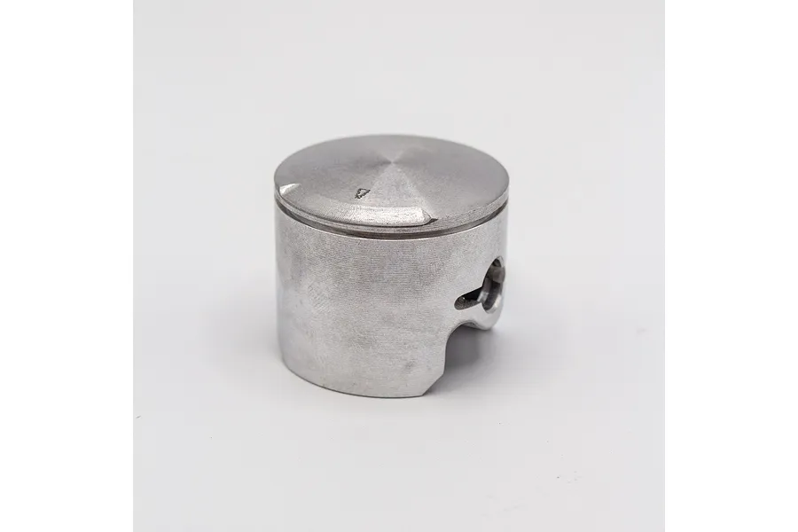 A silver metal RC engine piston against a clean white studio background.