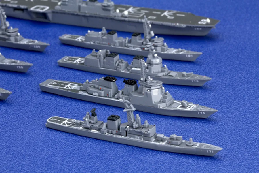 Assembled plastic scale model ship kits of the JMSDF Escort Flotilla 1 displayed on a blue surface.