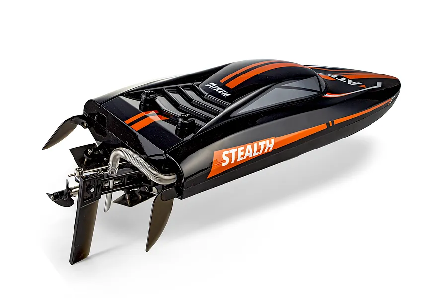 Rear-angle studio shot of the Atrek Stealth black and orange RC speed boat showing the propeller and rudder assembly.