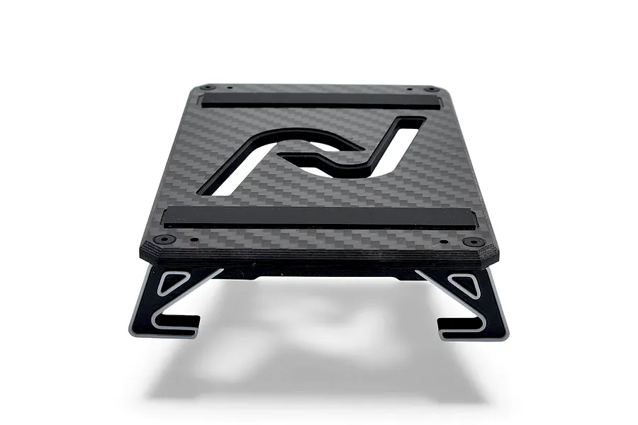 INOV8 3DX carbon fibre RC car stand with silver accents, viewed from a low angle on a white background.
