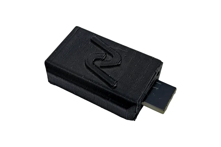 INOV8 3DX Non-Polarity Micro Capacitor in a black 3D printed enclosure on a white background.