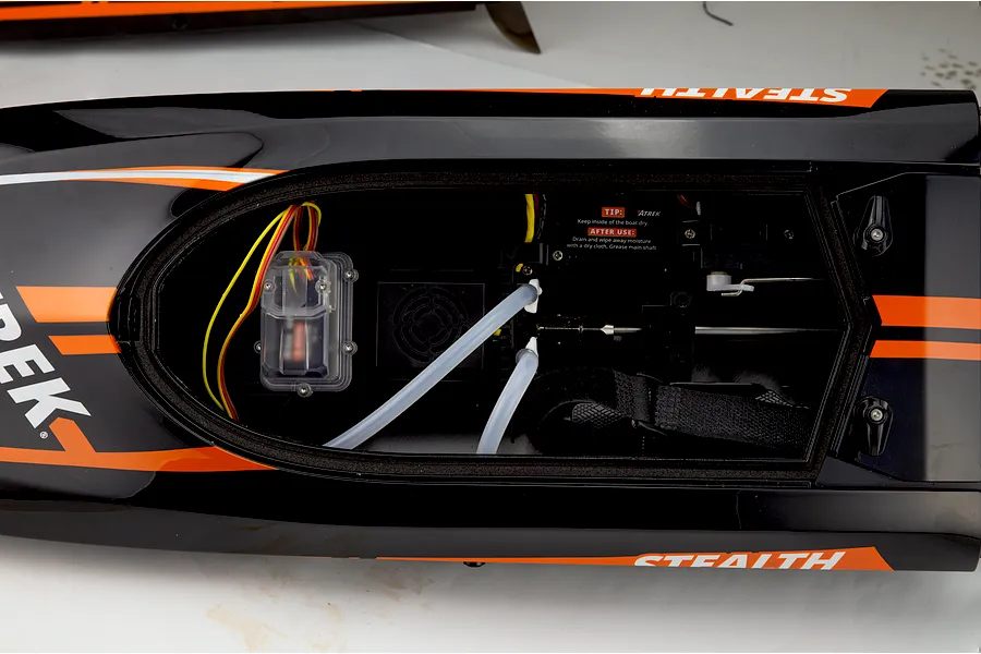 Top-down view of the open hull interior of the Atrek Stealth RC boat, showing electronics, cooling lines, and motor mount.
